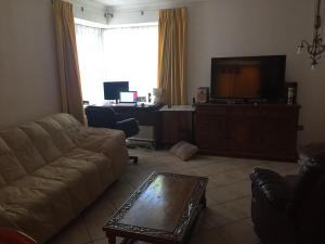 a living room with a couch and a flat screen tv at habitaciones exclusivas in Curicó