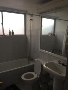a bathroom with a white toilet and a sink at habitaciones exclusivas in Curicó +8 photos