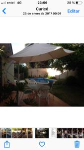 a picture of a table with an umbrella at habitaciones exclusivas in Curicó