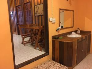a bathroom with a sink and a table with a mirror at บ้านศรีสมบูรณ์ เชียงคาน in Chiang Khan