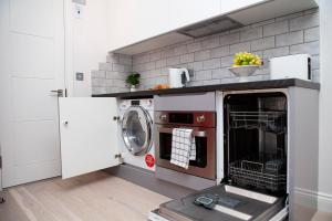 a kitchen with a washing machine in a kitchen at Carnaby Studios by Indigo Flats in London