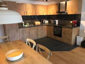 a kitchen with wooden cabinets and a wooden table at Apartment Seeglück am Schliersee - modern, zentral, perfekt für Familien in Schliersee