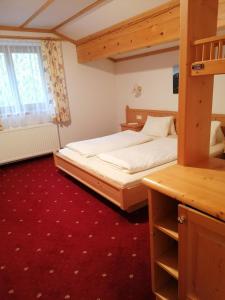 een slaapkamer met een stapelbed en een rode loper bij Berggasthof Hintergföll in Unken