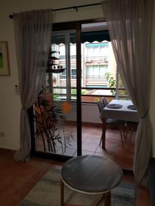 桑特霍安達拉坎特的住宿－Estudio en el centro de San Juan de Alicante，客厅配有桌子和玻璃门