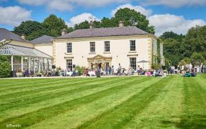 un grande gruppo di persone che si trovano di fronte a una grande casa di Castle Grove Country House Hotel a Letterkenny