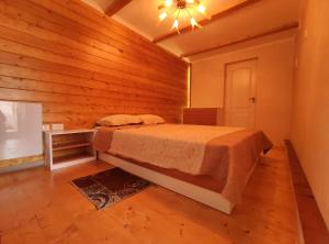 a bedroom with a bed in a room with wooden walls at садиба Пан Коцький in Kosiv