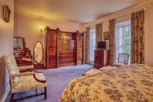 Castle Grove Country House Hotel في ليتيركيني: غرفة نوم بسرير ومكتب وخزانة