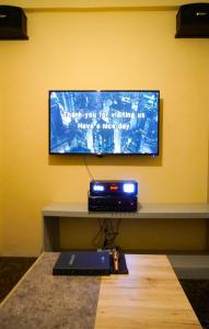 a flat screen tv hanging on a yellow wall with a table at ParmView Inn in Legazpi
