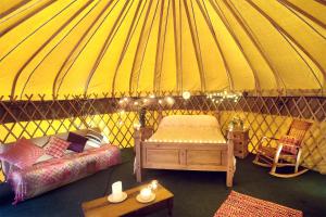 an interior of a yurt with a bed and a table at Portsalon Luxury Camping in Portsalon