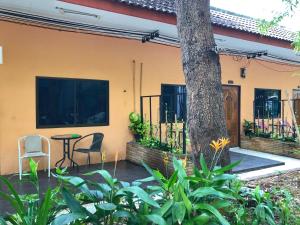 een patio met een tafel en stoelen voor een huis bij Fairtex Residence Pattaya in Noord Pattaya