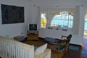 a living room with a couch and a tv at Kuwona Cottage in Senga