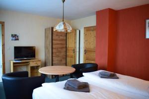 Zimmer mit 2 Betten, einem Tisch und einem TV in der Unterkunft Landhotel "Lichte Aue" Lichtenau in Stützengrün