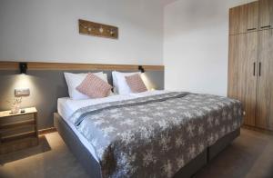 a bedroom with a large bed and a wooden cabinet at Resort Dworzysko in Szczawno-Zdrój