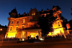 budynek w nocy z osobą stojącą przed nim w obiekcie Hotel Villa Carlton - Adults Only w mieście Salzburg
