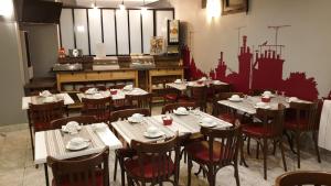 a dining room with tables and chairs in a restaurant at Hotel Paris Villette in Paris