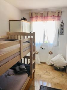 a room with two bunk beds and a window at Apartamento con terraza y piscina en Malgrat de Mar in Malgrat de Mar