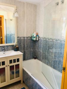 uma casa de banho com uma banheira e um lavatório em Apartamento con terraza y piscina en Malgrat de Mar em Malgrat de Mar