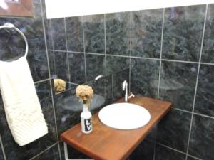 a bathroom with a sink and a vase of flowers at Casa Rô in Tiradentes +26 photos