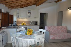 een keuken met een tafel met stoelen en een eetkamer bij Le Bozze "Il Frantoio" con piscina, Wi-Fi, posto auto in Castagneto Carducci