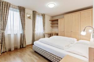 a bedroom with a large bed and a window at Apartments Petlin in Ortisei
