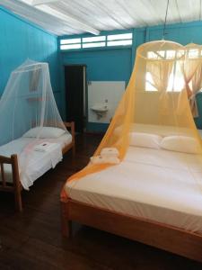 Puerto Nariño的住宿－Eware Refugio Amazonico，客房设有两张带蚊帐的床。