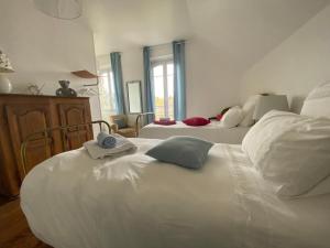 a bedroom with two white beds and a window at Les Chambres de LOUIS in Le Chesnay