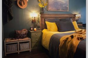 a bedroom with a bed with yellow pillows and a dresser at CELYN - SNOWDONIA COTTAGE in Caernarfon