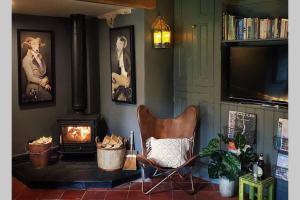 a living room with a chair and a fireplace at CELYN - SNOWDONIA COTTAGE in Caernarfon