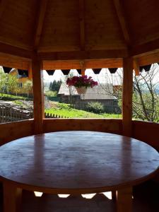 einen Holztisch in einem Pavillon mit einem Fenster in der Unterkunft Ансол in Worochta