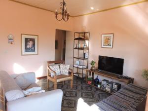 a living room with a couch and a tv at Casa Rô in Tiradentes