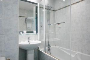 a bathroom with a sink, toilet and bathtub at Hôtel Du Port in Morlaix