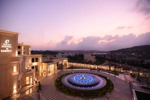 a large building with lights in a courtyard at night at Opal Hotel Amman in Amman
