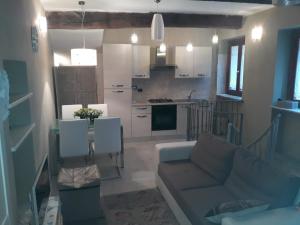 a living room with a couch and a kitchen at Antico Vicolo - Appartamento Giulia in Vercelli