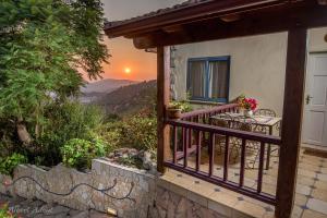 a balcony of a house with a table and a sunset at Dream Time in Amirim