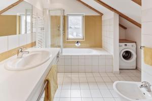 a bathroom with two sinks and a washing machine at Apartments Petlin in Ortisei