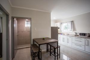a kitchen with a table and a refrigerator at Curadise Living in Willemstad