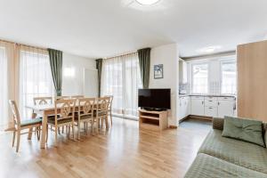 a living room with a dining room table and a kitchen at Apartments Petlin in Ortisei