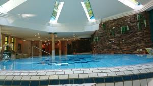 - une grande piscine dans un bâtiment avec un mur en pierre dans l'établissement Villa Hammerschmiede, à Söllingen