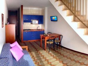 un salon avec une table et une cuisine dans l'établissement Residence Carina, à Bibione