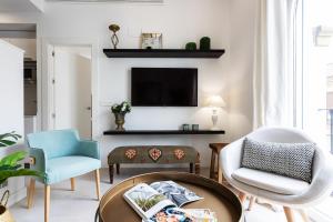 a living room with two chairs and a tv at Genteel Home Mateos Gago in Seville