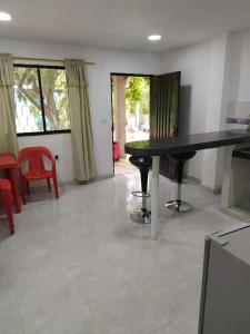a living room with a black table and red chairs at Emvacamo' in Taganga