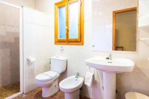 een witte badkamer met een toilet en een wastafel bij Apartamentos Arenal Playa in Punta Grossa