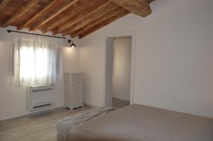 un dormitorio con una cama y una ventana en Le Bozze "Il Frantoio" con piscina, Wi-Fi, posto auto, en Castagneto Carducci