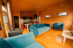 a living room with blue couches and a kitchen at Loica in Pichilemu