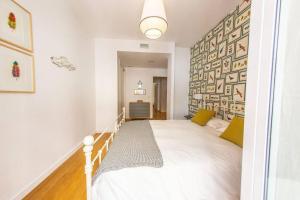 - une chambre avec un grand lit blanc et des oreillers jaunes dans l'établissement Next to the Mushrooms, bird room., à Séville