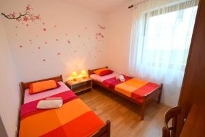 two twin beds in a room with a window at Apartment Zdenka in Njivice