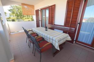 a table and chairs on a balcony with a view at Apartment Zdenka in Njivice