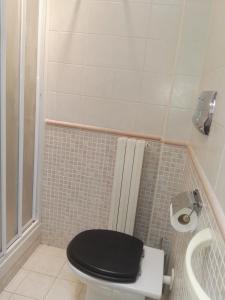 a bathroom with a toilet with a black lid at La terrazza di Maja in Chieti