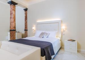 a bedroom with a large white bed and two columns at Villa Natalia Luxury Rooms in Verona
