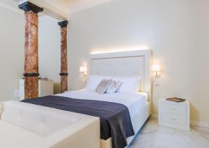 um quarto com uma grande cama branca e duas colunas em Villa Natalia Luxury Rooms em Verona